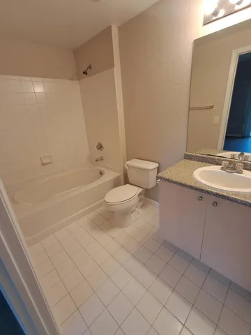 a bathroom with a granite countertop sink a toilet and a bathtub
