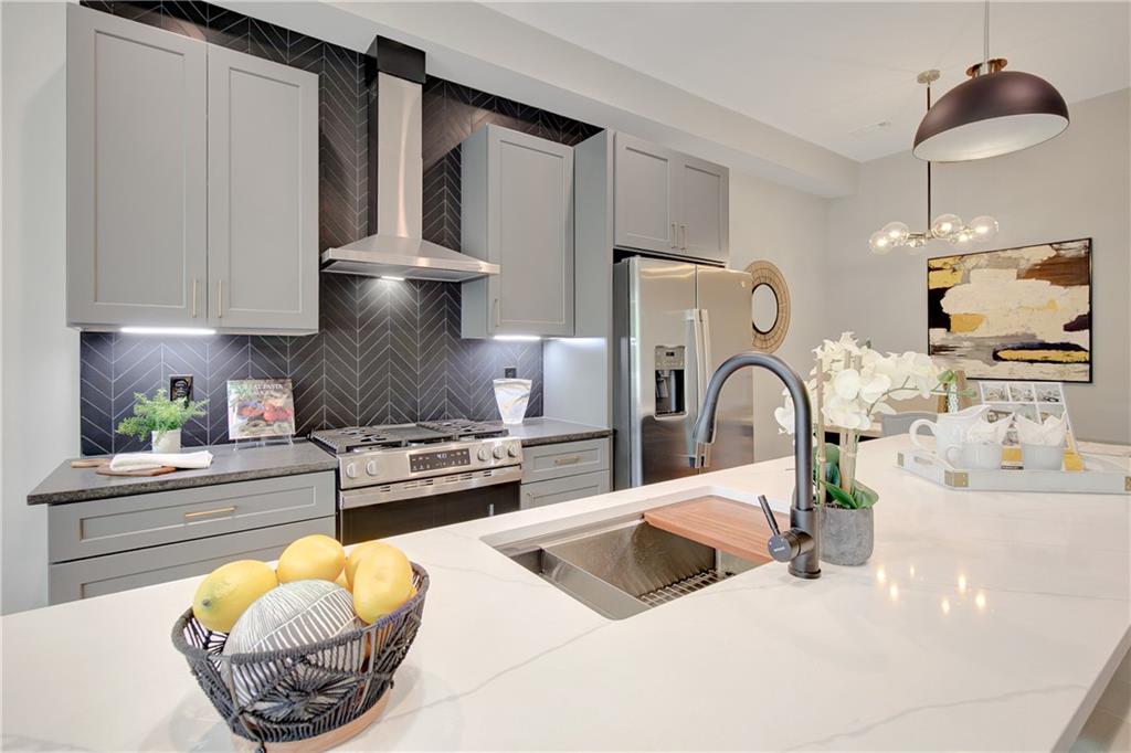 458 Connally Street Southeast Atlanta, GA 30312 - Photo 6 of 51 a kitchen with stainless steel appliances a sink a stove and a wooden floor