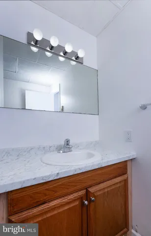 a bathroom with a sink a light fixture and a mirror