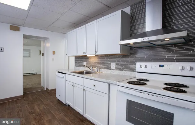 a kitchen with a stove and white cabinets
