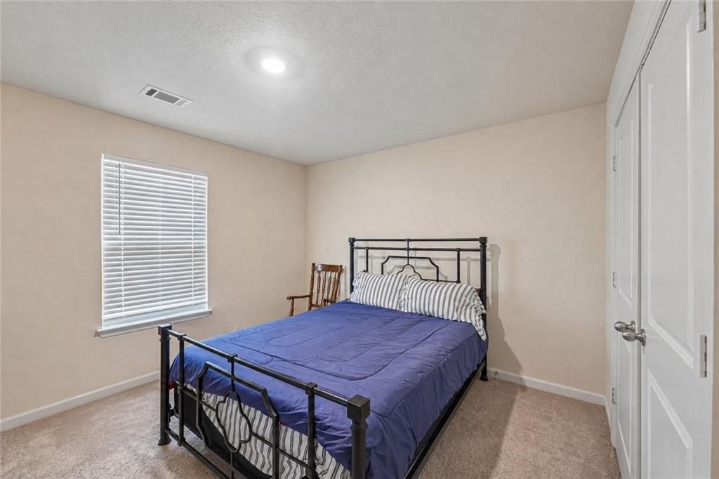 10933 Wheeler Trace Hampton, GA 30228 - Photo 12 of 22 a bedroom with a bed and a window
