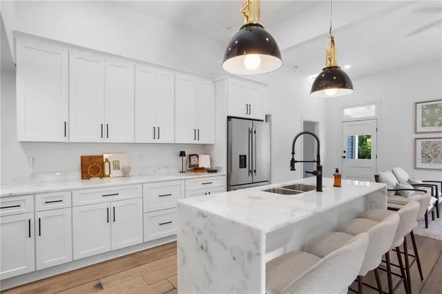 a kitchen with white cabinets and chandelier