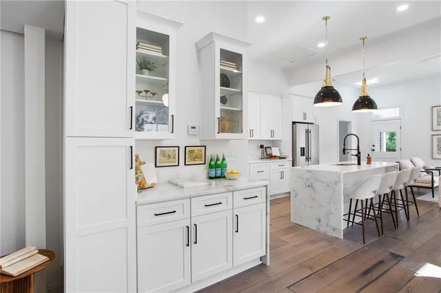 a large white kitchen with lots of counter space and breakfast area