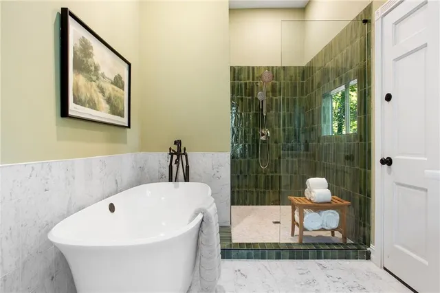 a white bath tub sitting next to a white sink and vanity