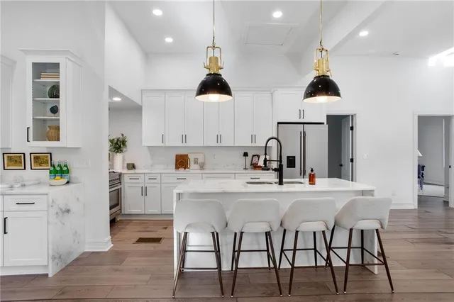 a kitchen with stainless steel appliances a dining table chairs stove and cabinets