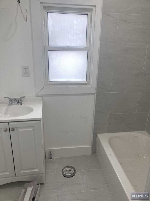 a bathroom with a sink a vanity and a bathtub