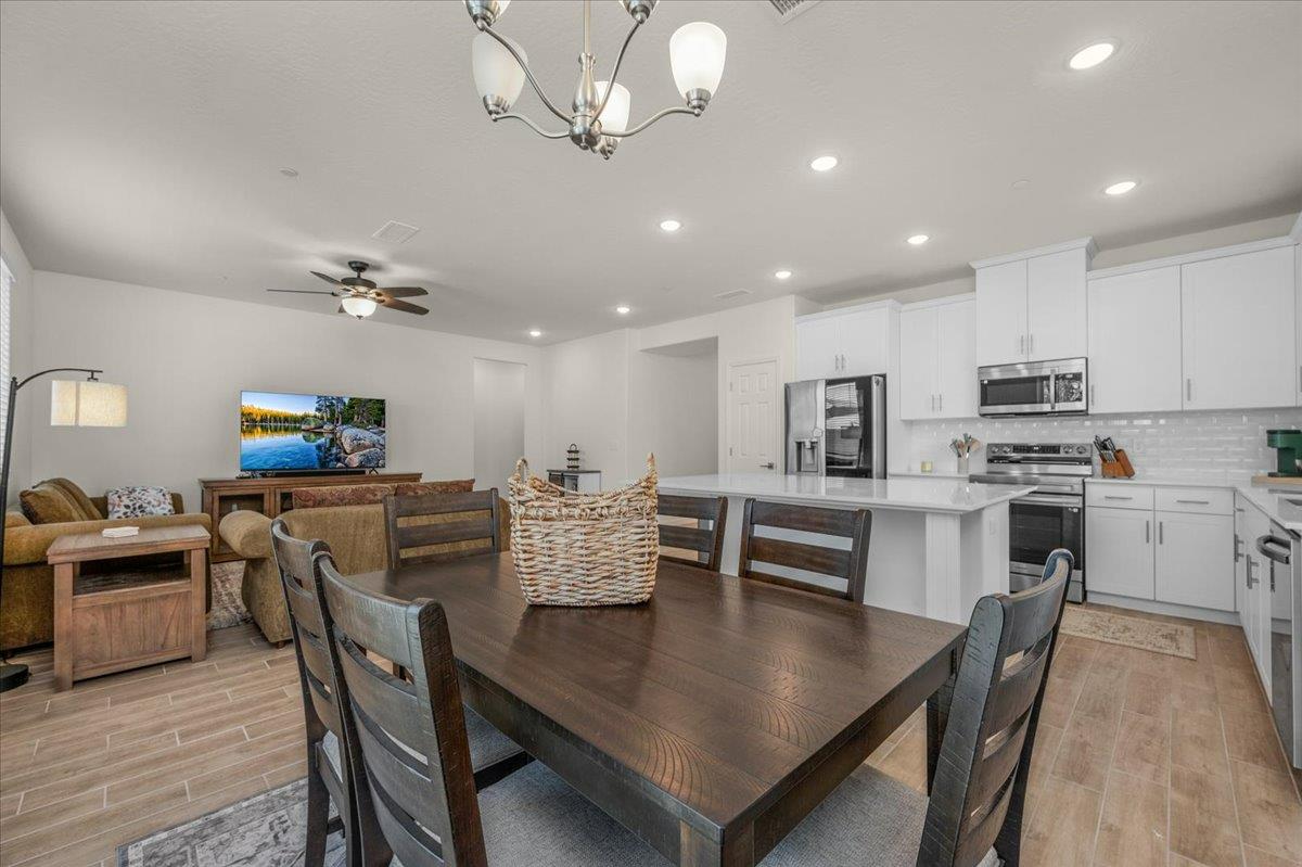 1183 Encore Way West Madera, CA 93636 - Photo 18 of 46 a view of a dining room with furniture a kitchen and chandelier