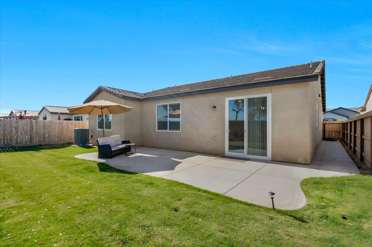 1183 Encore Way West Madera, CA 93636 - Photo 4 of 46 a view of a backyard with table and chairs and wooden fence