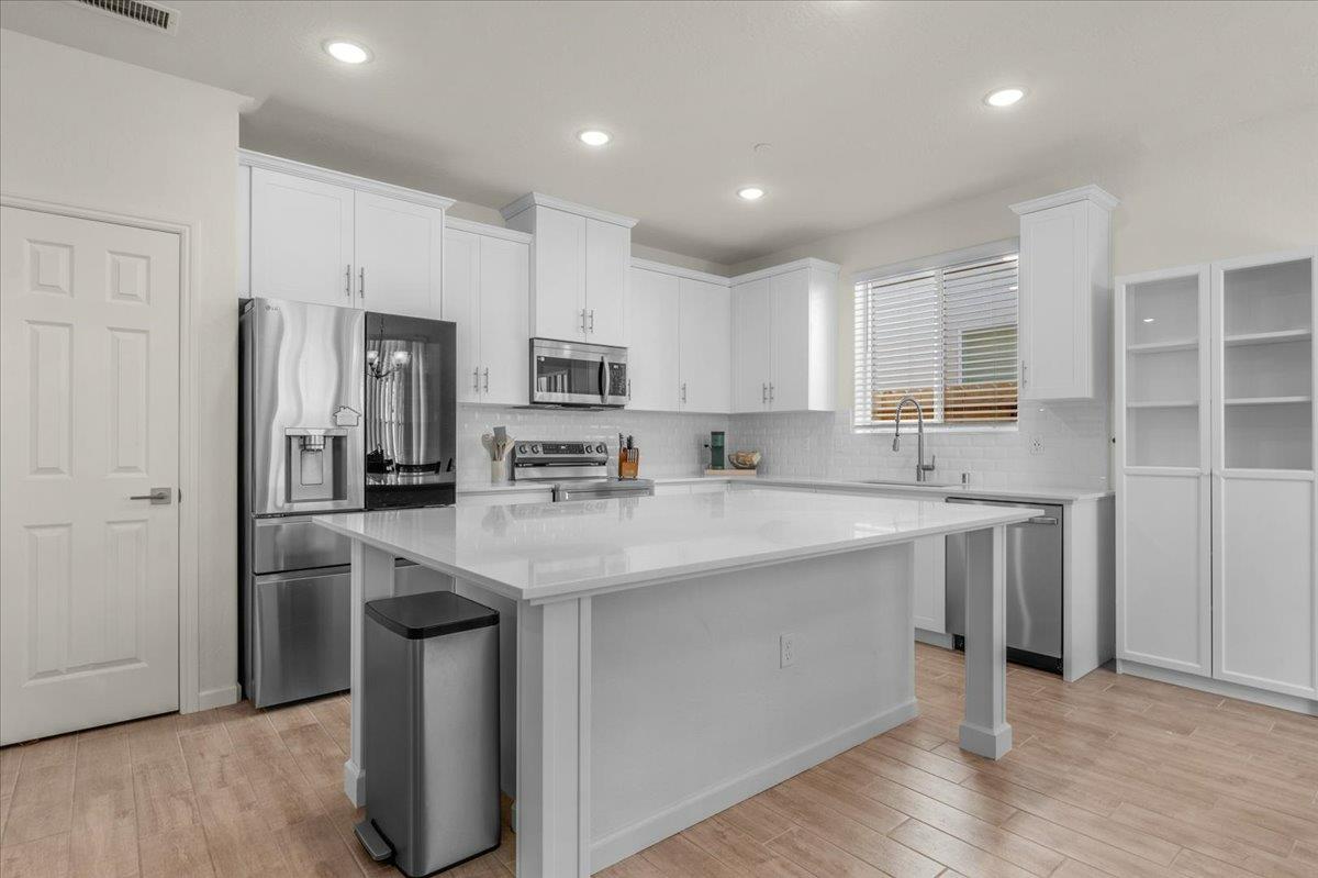 1183 Encore Way West Madera, CA 93636 - Photo 7 of 46 a kitchen with kitchen island granite countertop a sink stove and refrigerator