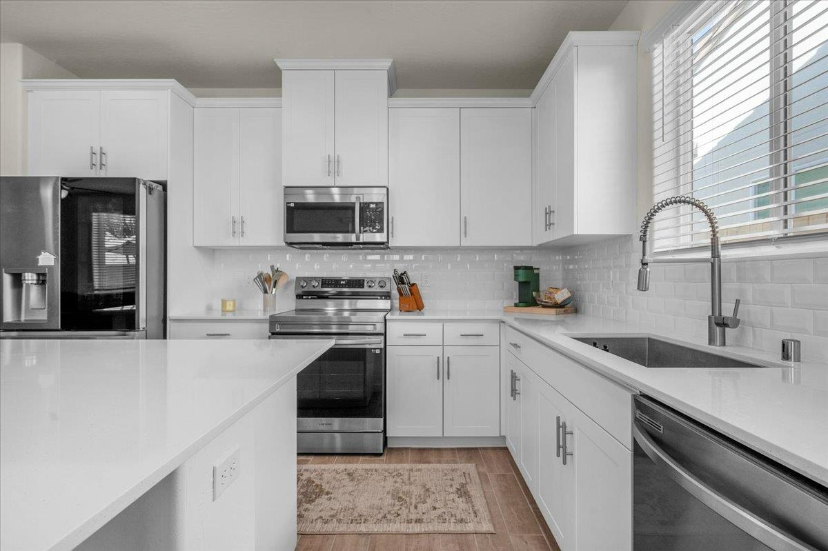 1183 Encore Way West Madera, CA 93636 - Photo 8 of 46 a kitchen with granite countertop a sink stainless steel appliances and white cabinets
