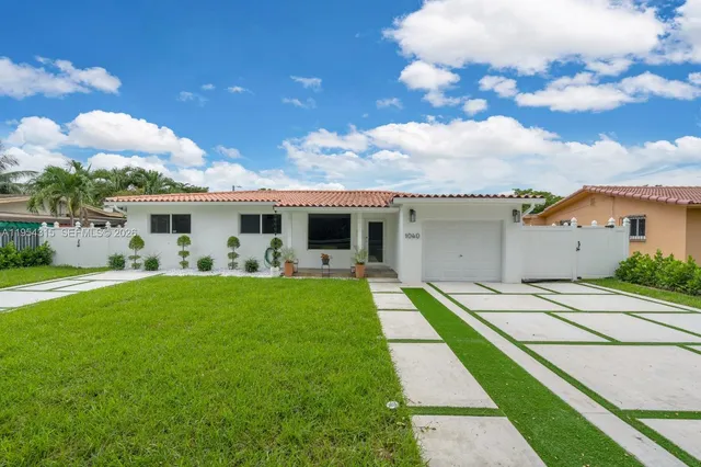 a view of a house with backyard sitting area and garden