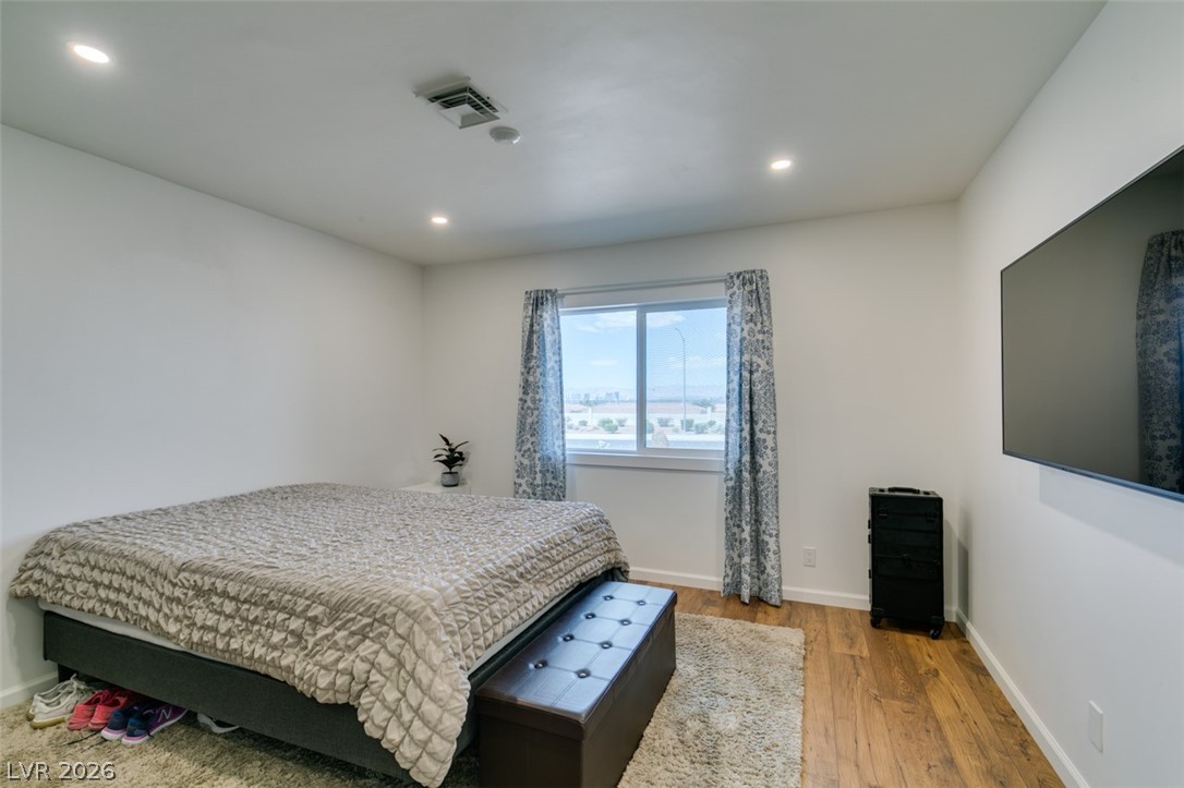 892 North Hollywood Boulevard Las Vegas, NV 89110 - Photo 42 of 81 This spacious bedroom features warm wood flooring and ample natural light, creating a serene retreat.