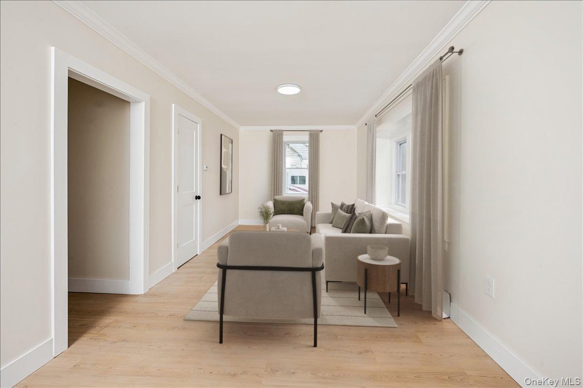a living room with furniture a window and a potted plant