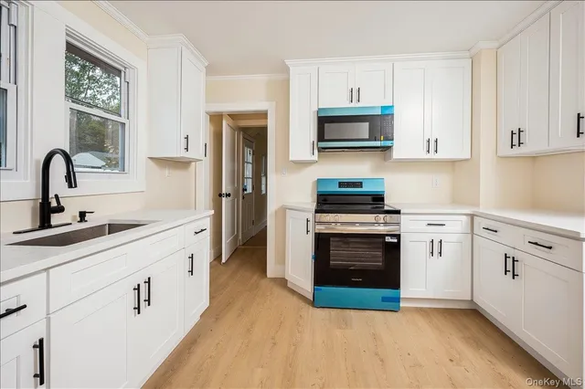 a kitchen with white cabinets and stainless steel appliances