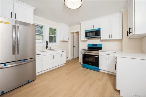 a kitchen with white cabinets and stainless steel appliances