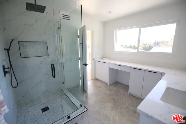 a bathroom with a granite countertop sink a mirror and a bathtub