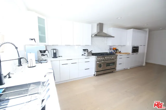 a kitchen with white cabinets and white appliances