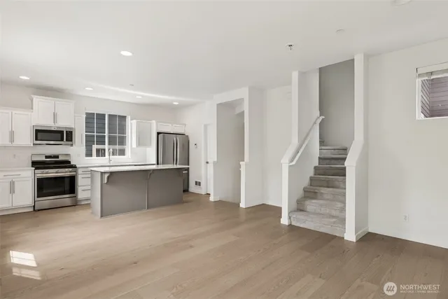 a kitchen with white cabinets and stainless steel appliances