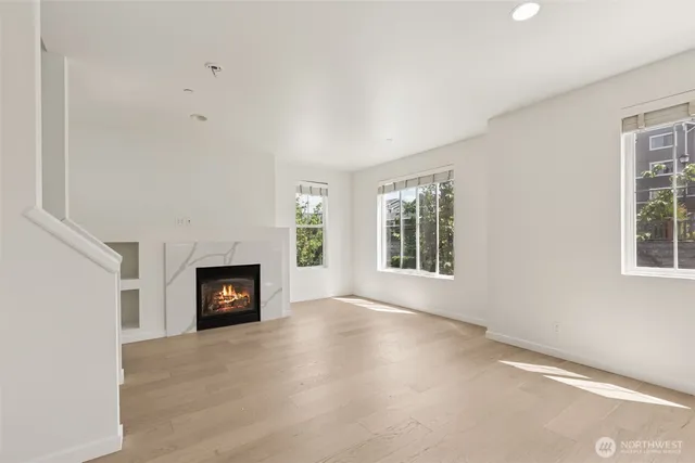 a view of an empty room with a fireplace and a window