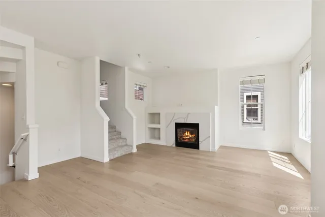 a view of a livingroom with wooden floor and a fireplace