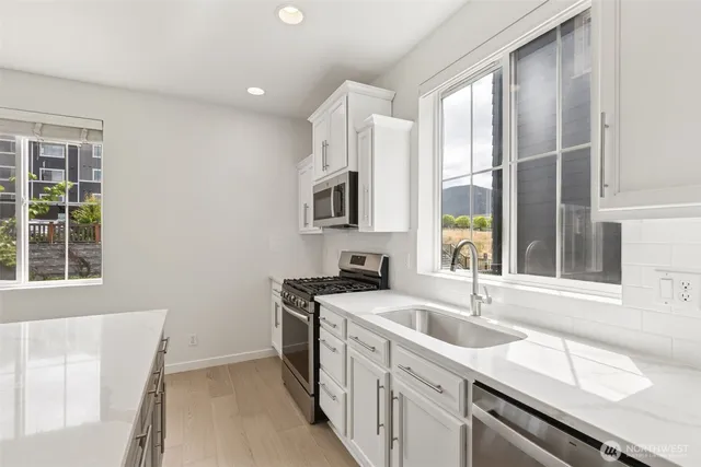 a kitchen with a sink stove top oven and refrigerator