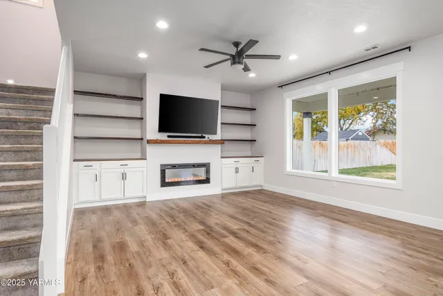 a view of a livingroom with a flat screen tv wooden floor and a window