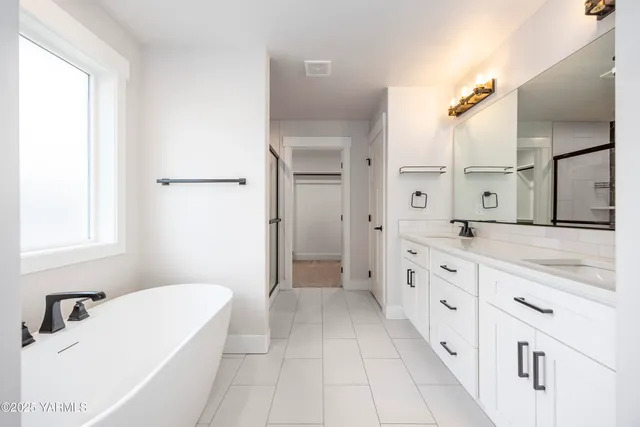 a bathroom with a granite countertop sink mirror and bathtub