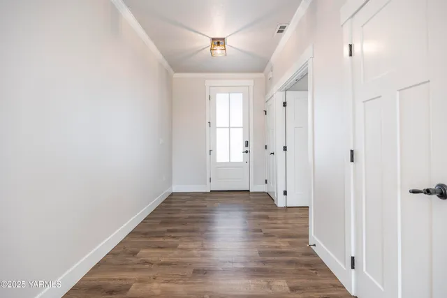 a view of an empty room with closet and a window