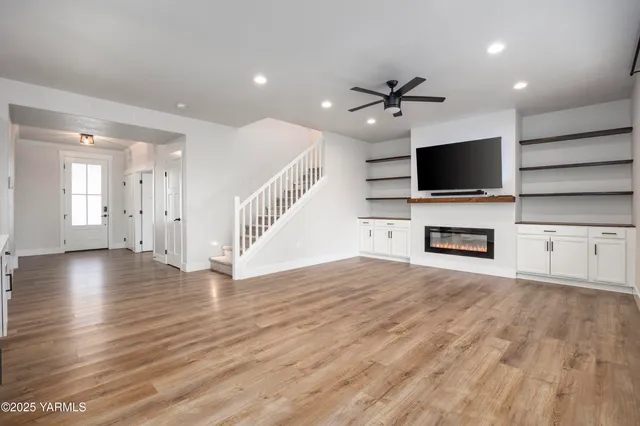 a view of a livingroom with wooden floor and a ceiling fan