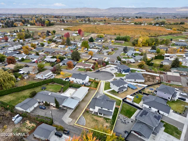 an aerial view of a city with lots of residential buildings and ocean view in back