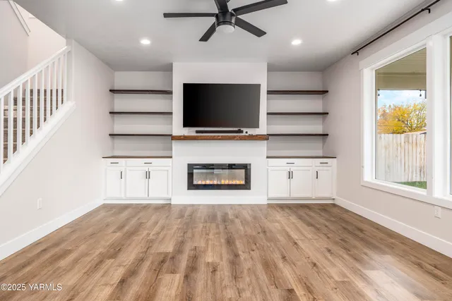 a living room with a flat screen tv fireplace and a window
