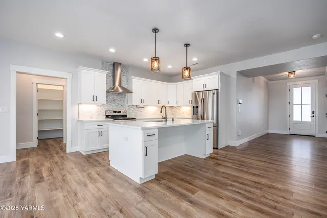 a kitchen with white cabinets stainless steel appliances and kitchen island