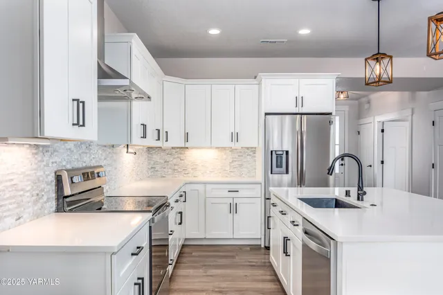 a kitchen with stainless steel appliances granite countertop a sink stove and refrigerator