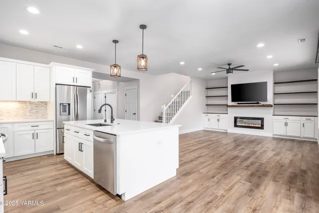 a large kitchen with stainless steel appliances kitchen island granite countertop a sink and a stove