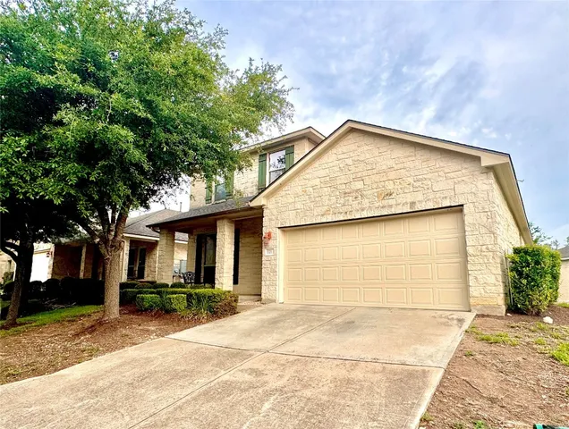 a backyard of a house with large trees and plants