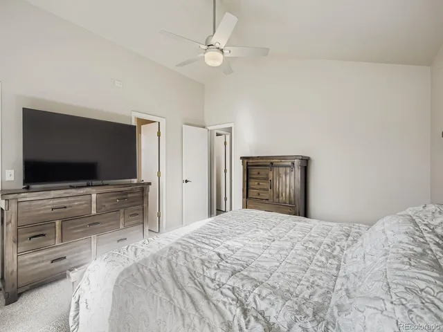 a bedroom with a bed and a flat screen tv in white walls