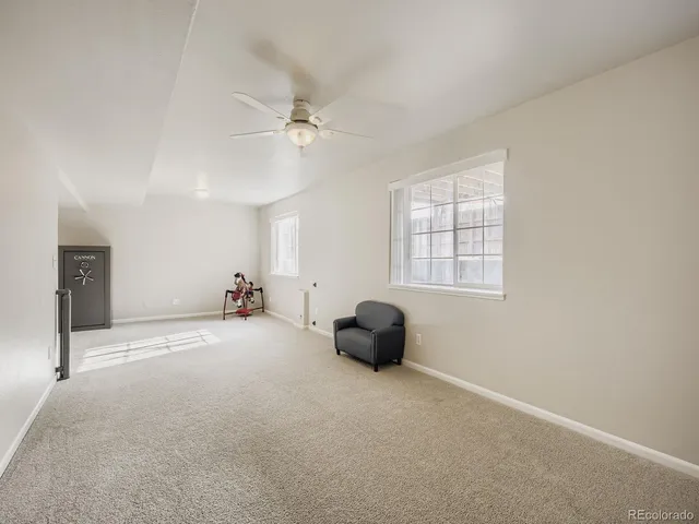 a view of a livingroom with a window and a ceiling fan