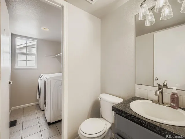 a bathroom with a granite countertop toilet sink and mirror