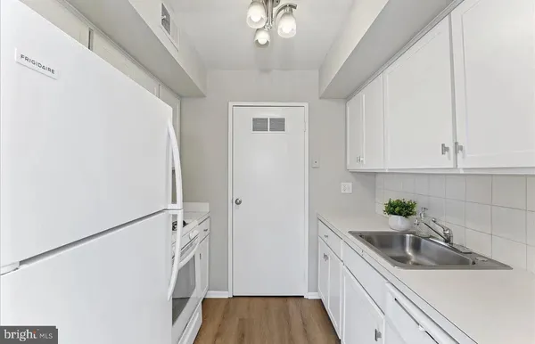 a kitchen with a sink a refrigerator and cabinets