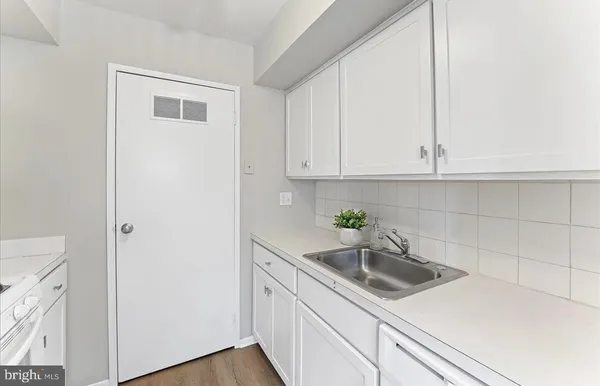 a kitchen with stainless steel appliances white cabinets and a sink