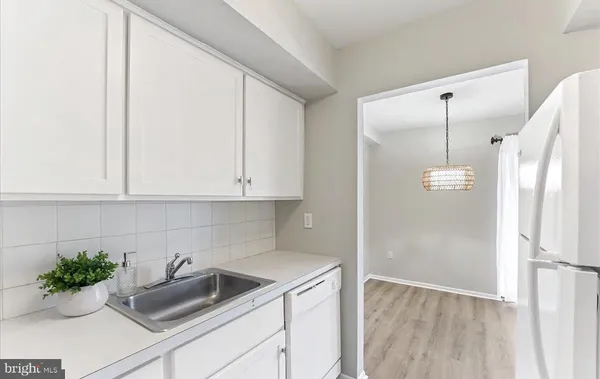 a kitchen with a refrigerator sink and cabinets