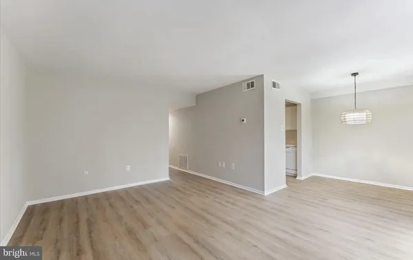 a view of a room with wooden floor and white walls
