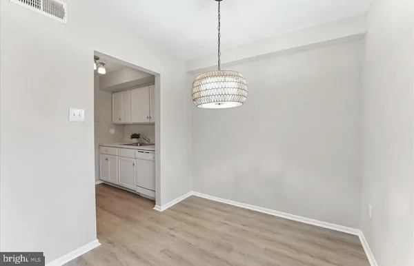 a view of kitchen with granite countertop white cabinets and window