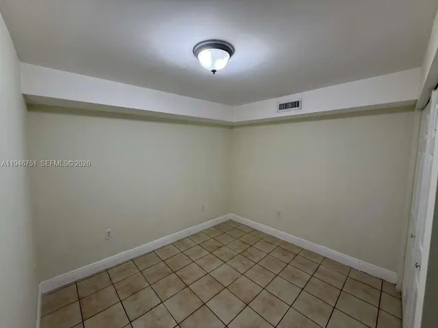 a view of a room with wooden floor and cabinets