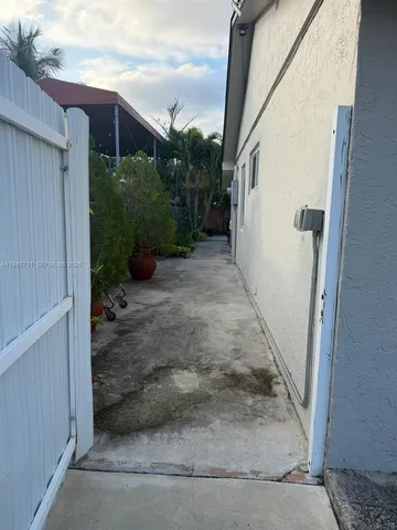 a view of a pathway of a house with wooden fence