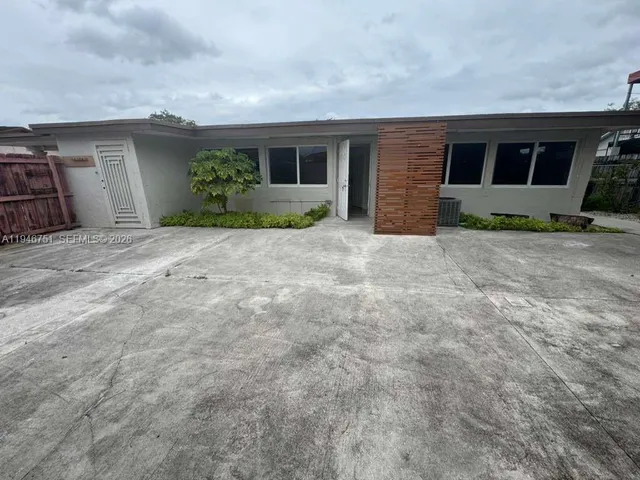a backyard of a house with plants and garage