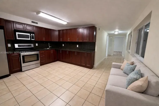 a large living room with stainless steel appliances cabinets