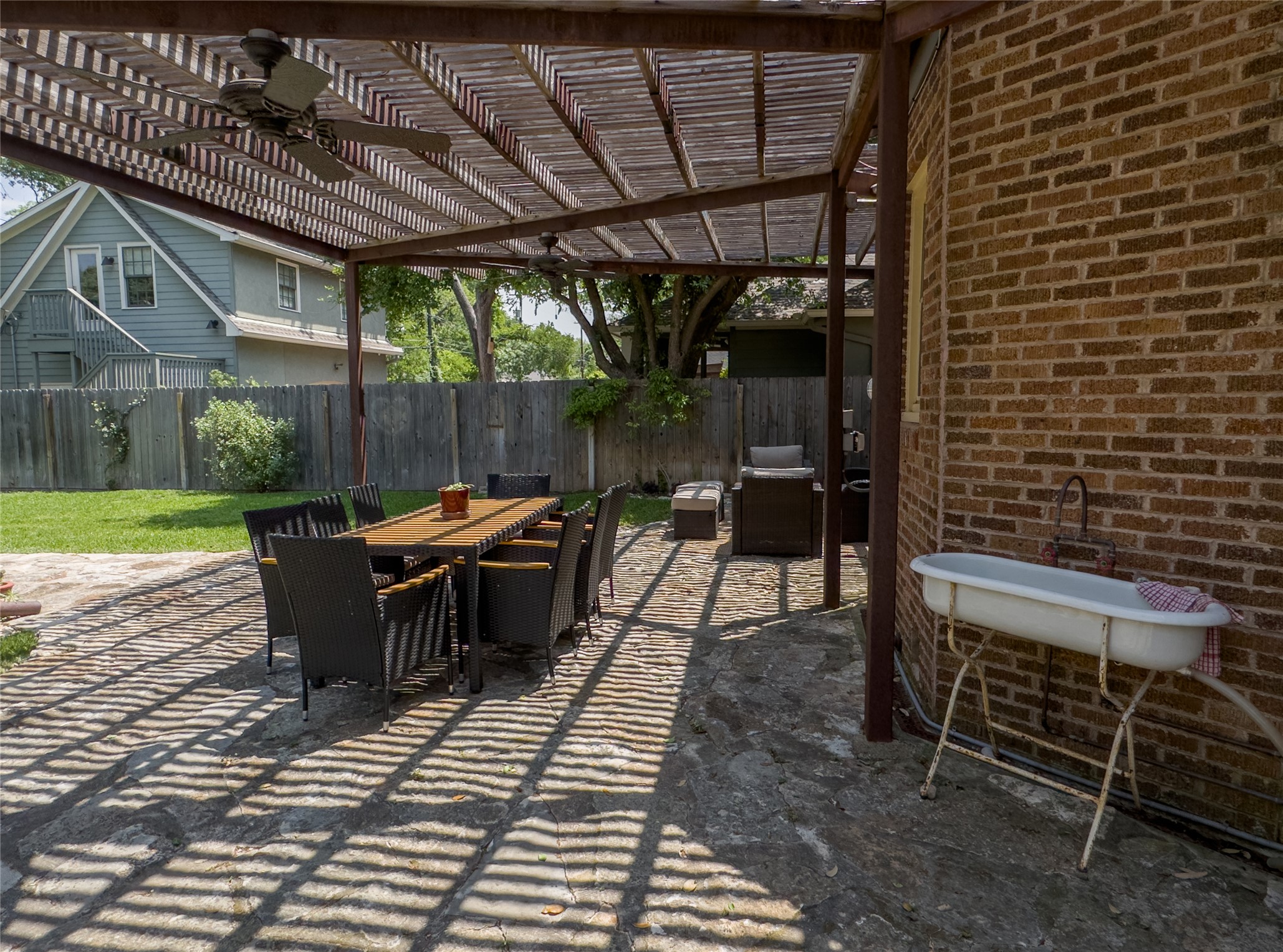 1512 Northwood Road Austin, TX 78703 - Photo 24 of 24 Fenced backyard featuring a patio, a pergola, outdoor dining area, and area for grilling