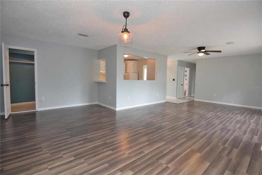 21572 Edgewater Drive Port Charlotte, FL 33952 - Photo 4 of 15 a view of an empty room with wooden floor and a ceiling fan