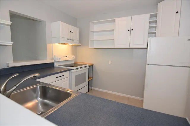a kitchen with a sink cabinets and a refrigerator